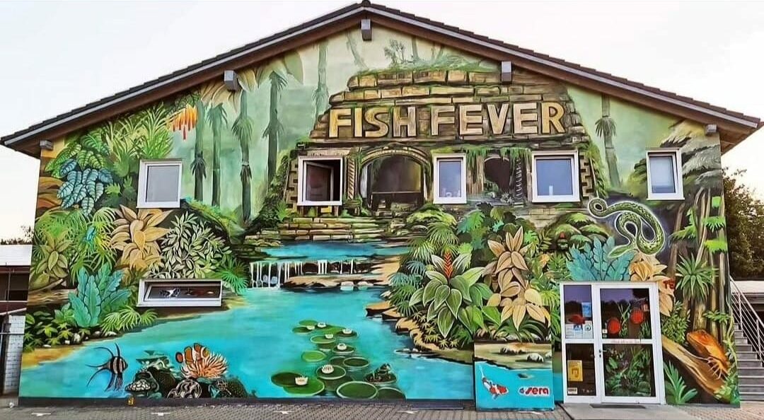 Fish Fever Ladengeschäft von außen mit großem Fish Fever Banner und Parkplatz vor dem Eingang